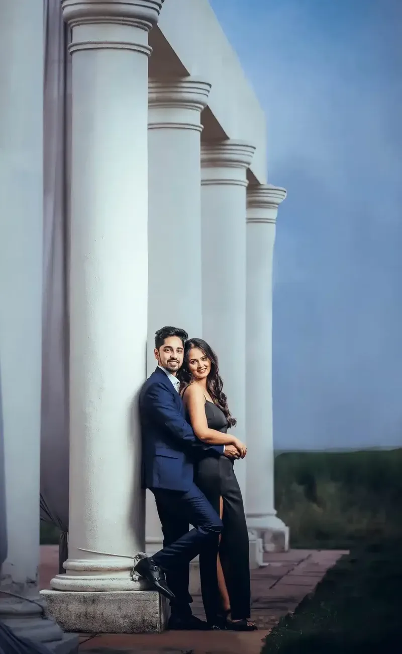 Couple in formal outfits during pre wedding shoot planning at a white pillar location