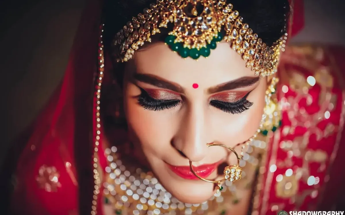 Close-up portrait of a bride in traditional gold jewellery and red dupatta, wedding photography in Indore
