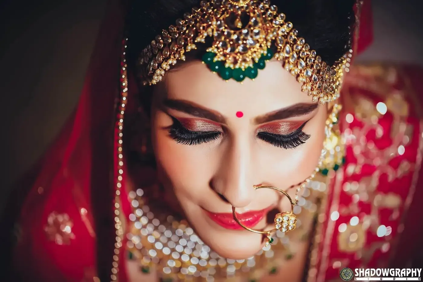 Close-up portrait of a bride in traditional gold jewellery and red dupatta, wedding photography in Indore
