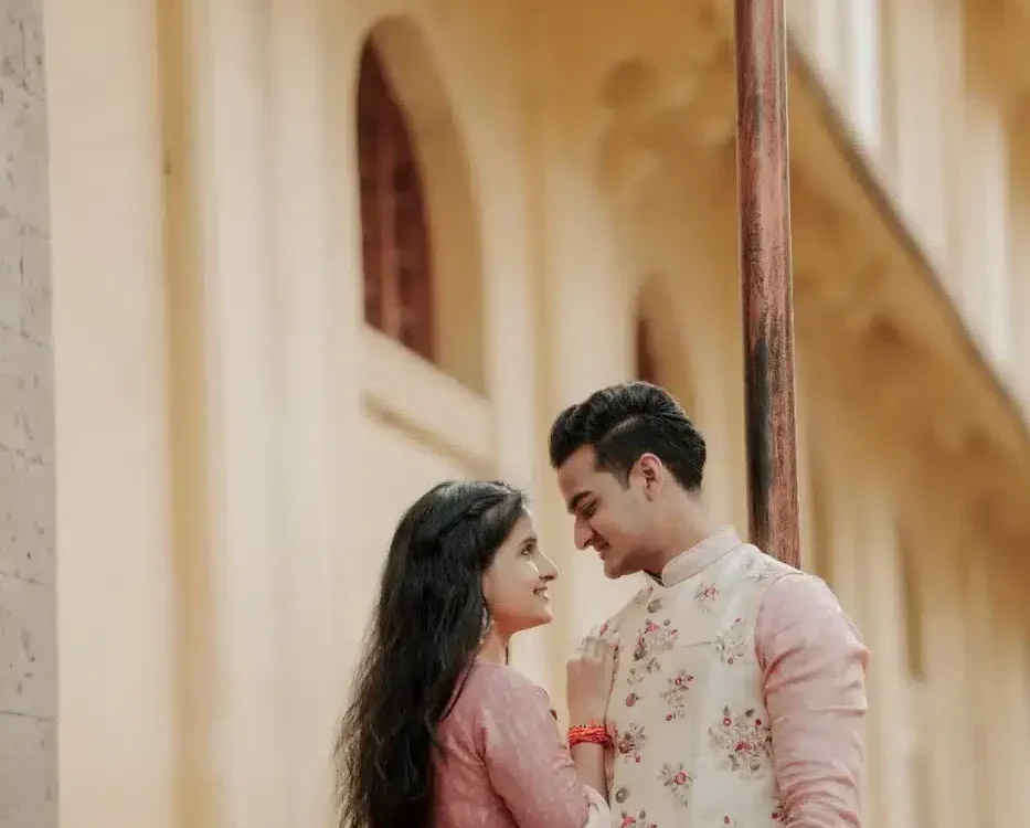 Couple in pink outfits at a heritage corridor, Indian wedding cost guide