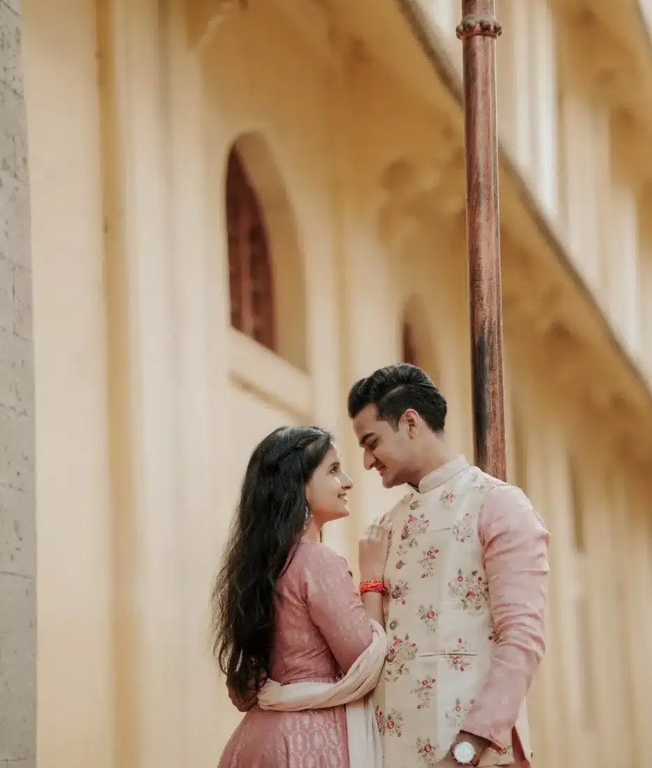 Couple in pink outfits at a heritage corridor, Indian wedding cost guide