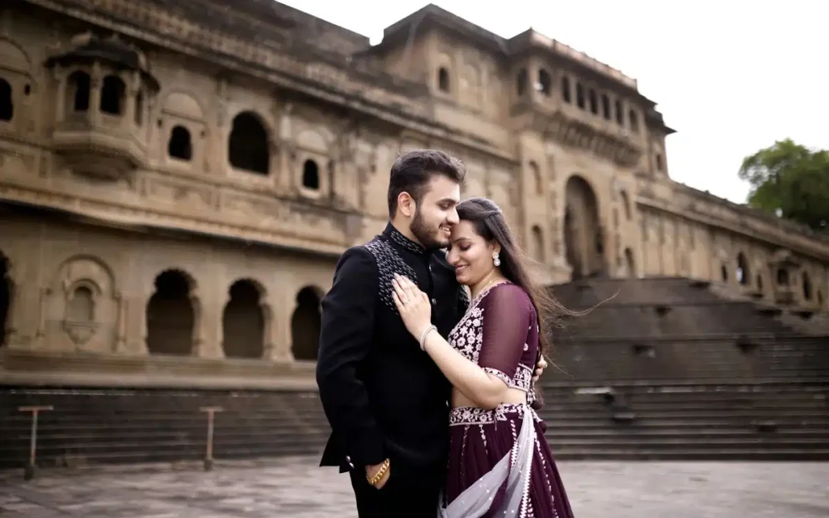 A couple embracing in front of the stone steps of a historic palace