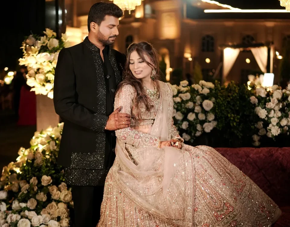 Couple in formal wedding outfits beside warm decorative lights, portrait for wedding album selection