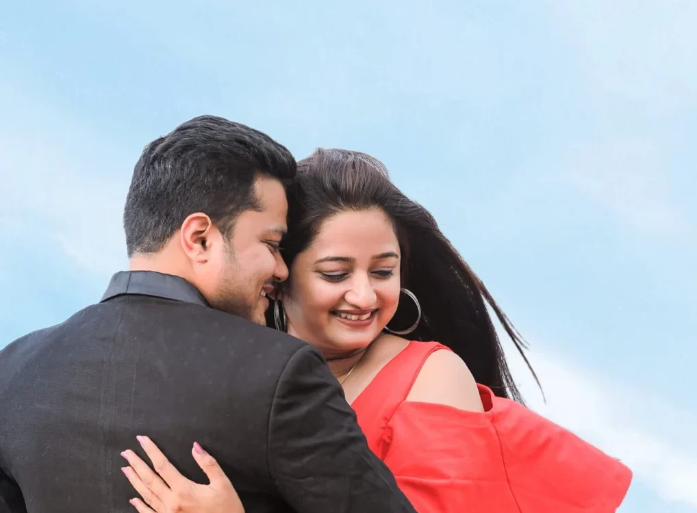 Couple laughing against a blue sky - wedding photography style that fits their personality