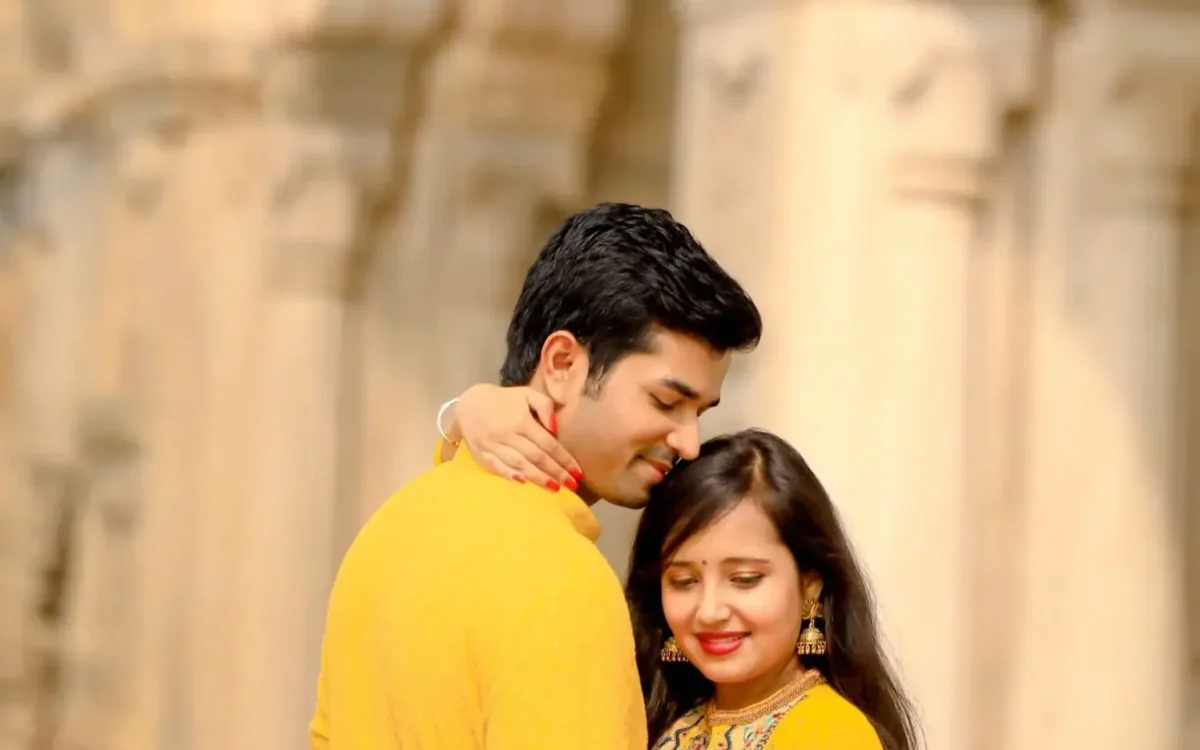 Couple in yellow outfits at heritage pillars during their wedding planning timeline