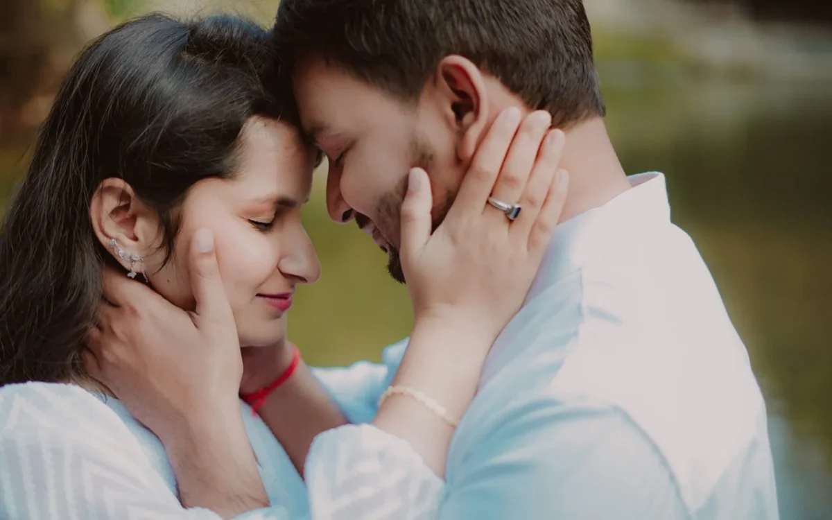 Couple touching foreheads with a ring visible on the woman's hand