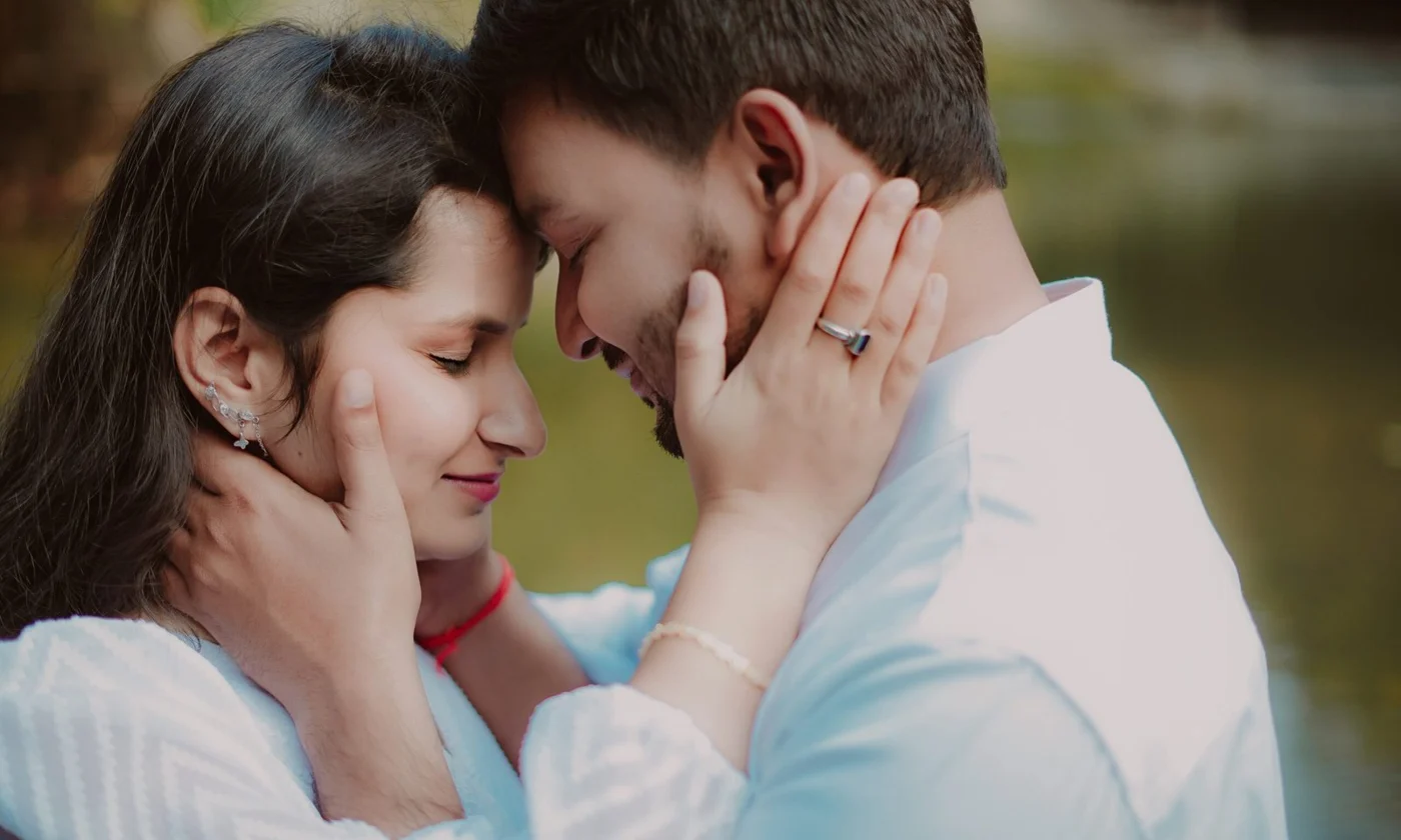 Couple touching foreheads with a ring visible on the woman's hand