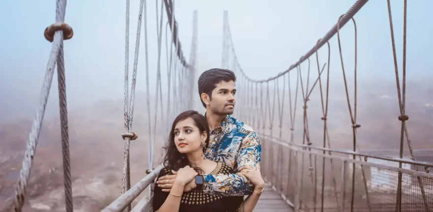 Outdoor couple portrait for the WPII rain photography planning guide Couple embracing on a misty suspension bridge during an outdoor portrait session
