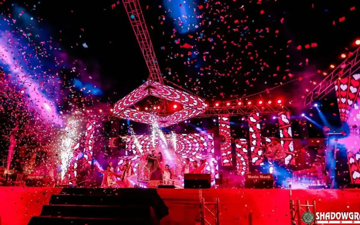Wedding stage decor lit in pink and purple with confetti, event photography in Indore