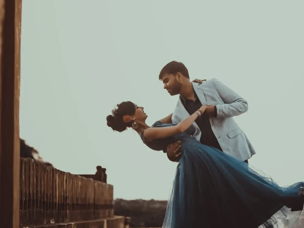 Couple in a cinematic dip under a heritage archway, wedding cinematography style frame