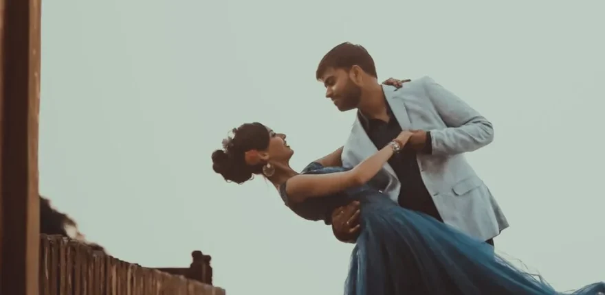Couple in a cinematic dip under a heritage archway, wedding cinematography style frame