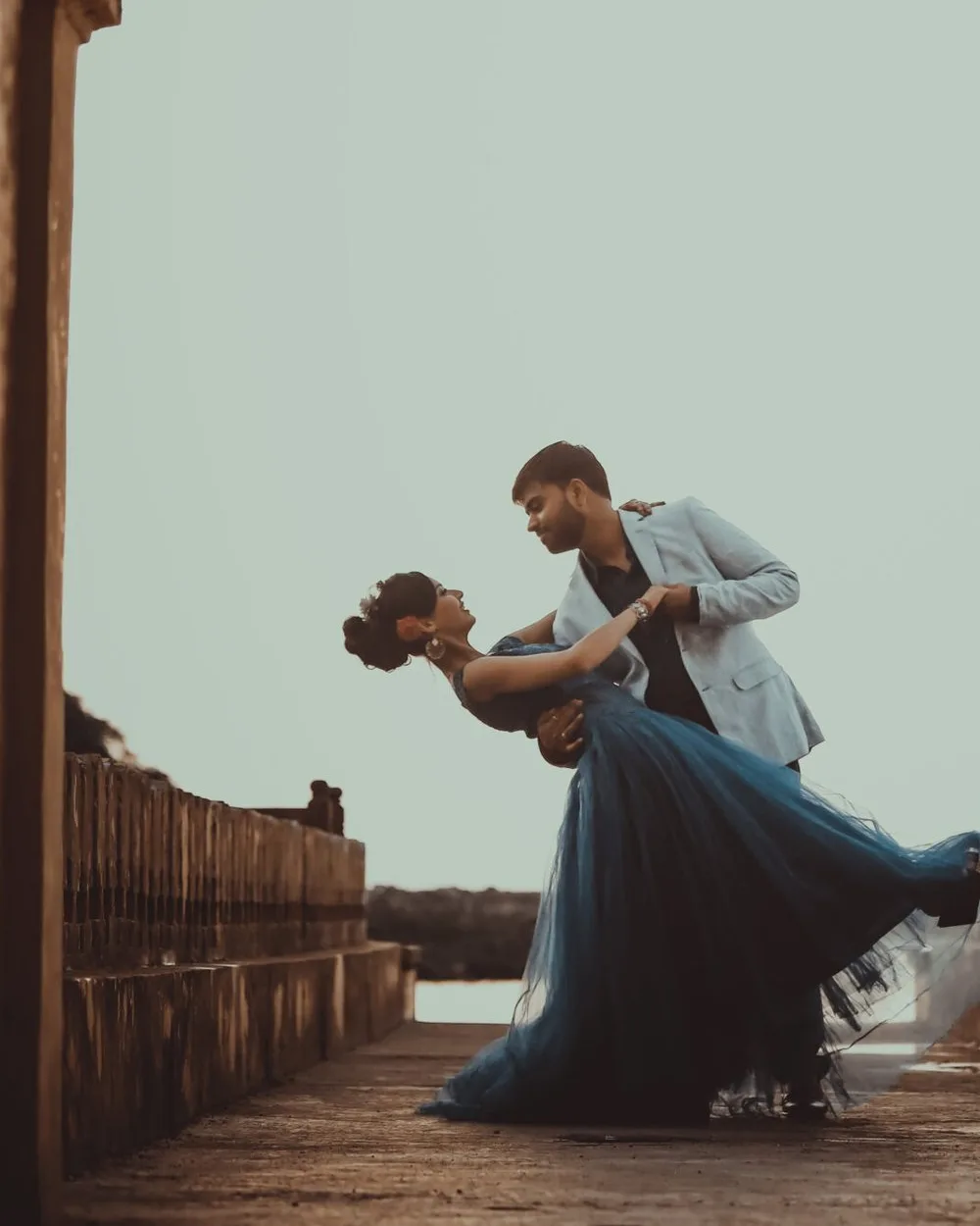 Couple in a cinematic dip under a heritage archway, wedding cinematography style frame