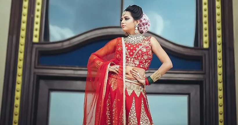 Bride in red lehenga portrait wedding photography Bride in a red lehenga standing in front of a tall window, wedding portrait