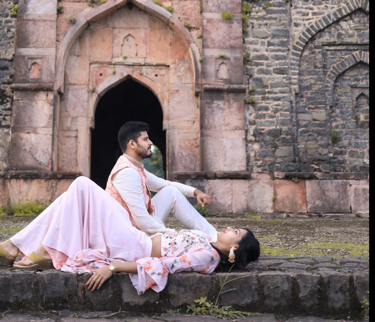 Couple at a heritage stone archway during a destination wedding photography session