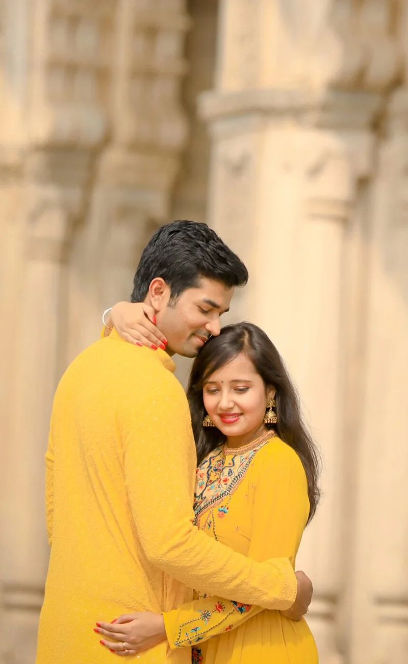 Couple in yellow traditional outfits during a luxury pre wedding shoot at a heritage building